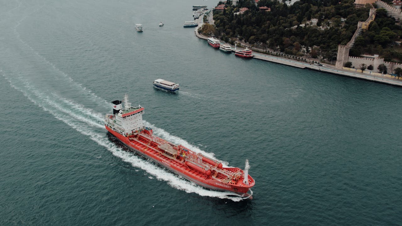 Cargo ship navigating through Bosphorus Strait, Istanbul under cloudy skies.